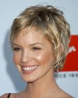 Ashley Scott wearing a short layered hairstyle with short bangs