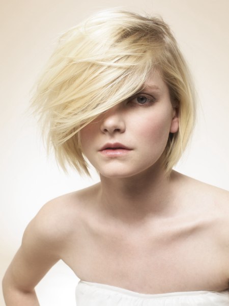 Modern baby blonde bob with long bangs and a textured cutting line