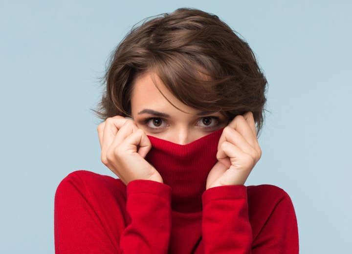 Woman who is hiding her face in a turtleneck